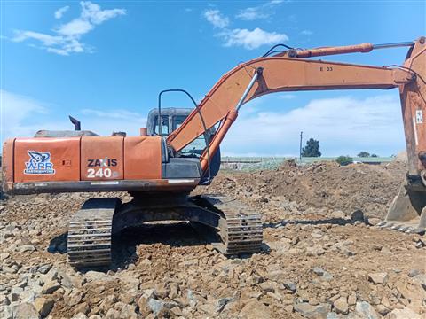 Orange Hitachi Zaxis 240 excavator working on a rocky site