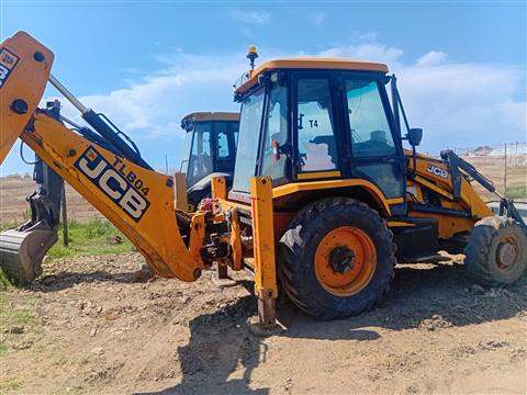 Orange and yellow JCB TLB with backhoe arm raised